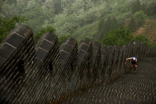 Уставший бегун на крутом участке Huangyaguan Великой стены в Great Wall Marathon (Пекин, Китай)